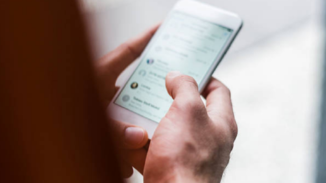 Teléfono celular mostrando chats de grupos de mensajería incautados por la policía.
