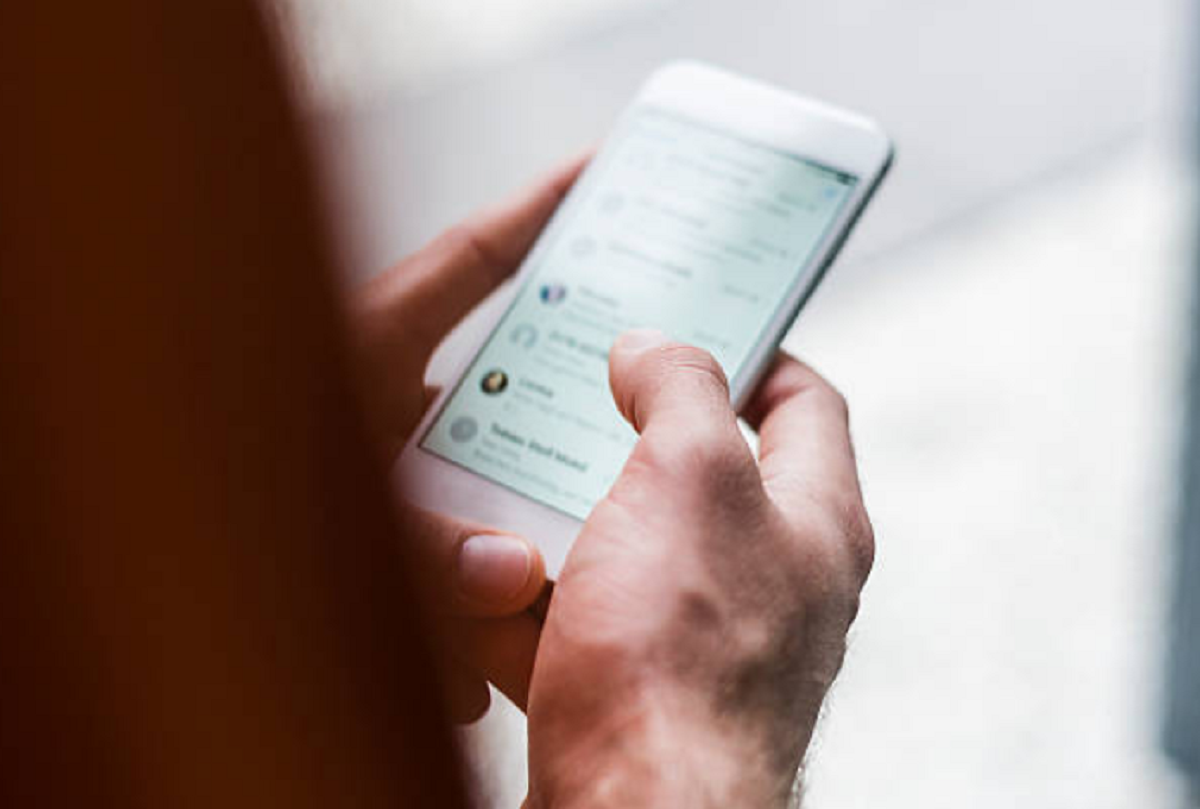 Teléfono celular mostrando chats de grupos de mensajería incautados por la policía.