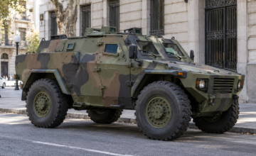 Vehículo blindado militar RPZ Cóndor pintado de camuflaje estacionado en una vía pública.