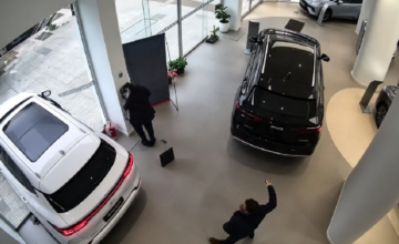 Una cámara de seguridad registra el momento en que un automóvil avanza desde el interior de una concesionaria, rompe la vidriera del local y finaliza sobre la vereda.