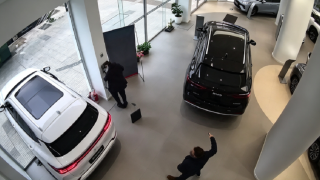 Una cámara de seguridad registra el momento en que un automóvil avanza desde el interior de una concesionaria, rompe la vidriera del local y finaliza sobre la vereda.