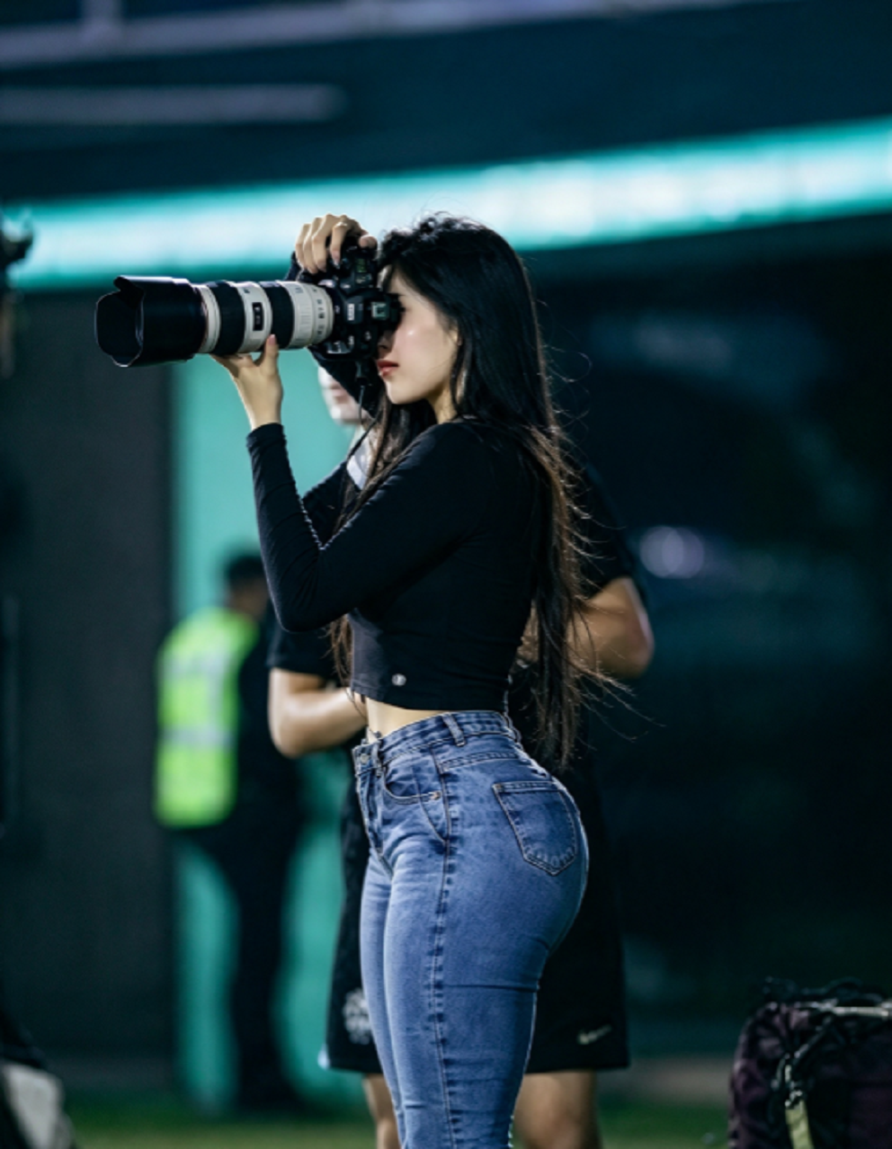 Reportera gráfica paraguaya trabajando durante la cobertura de un partido.
