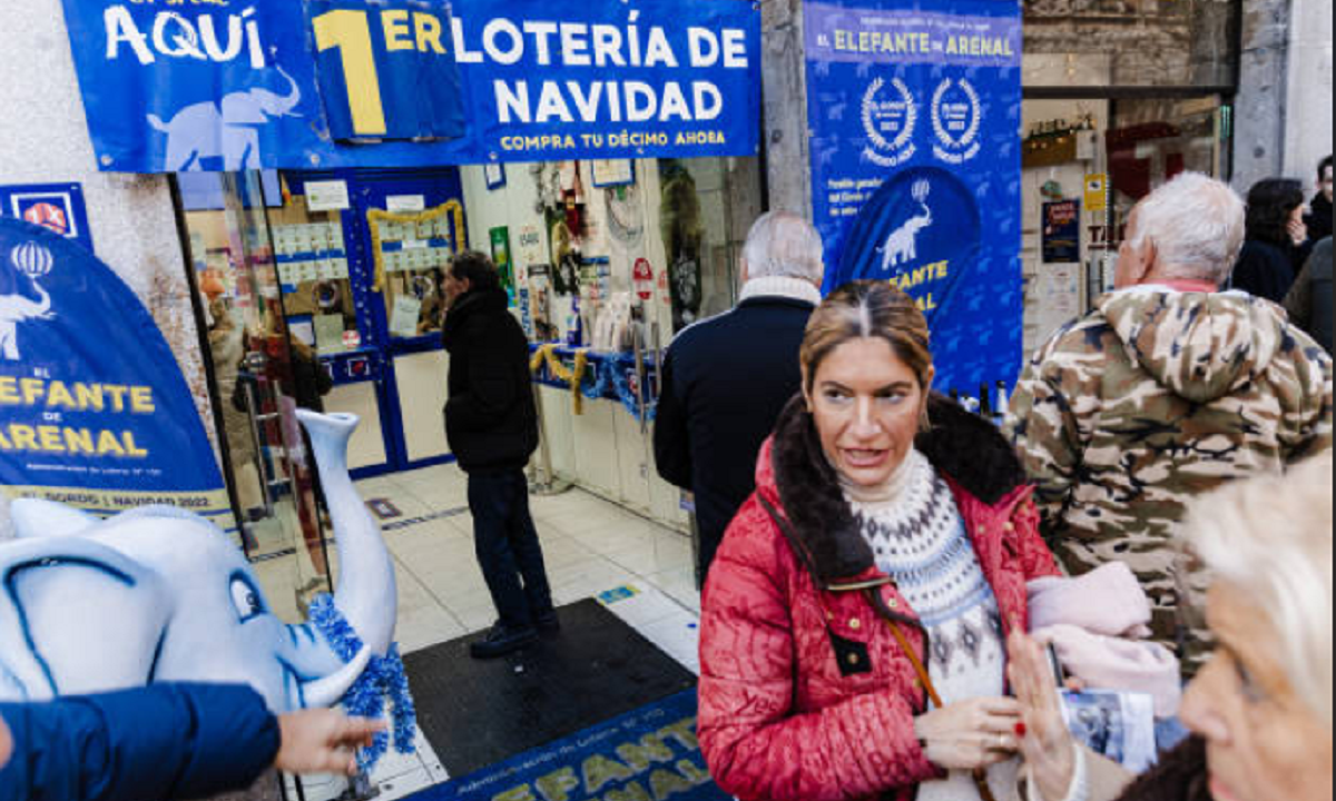 Cartel exterior de una administración de lotería tradicional en España con gente haciendo fila.