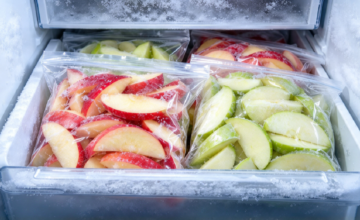 Manzanas cortadas en bolsas herméticas aptas para congelador en el freezer.