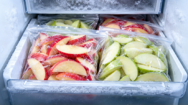 Manzanas cortadas en bolsas herméticas aptas para congelador en el freezer.