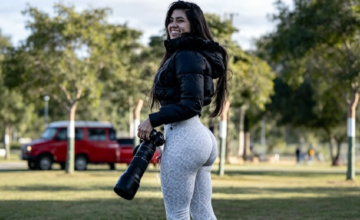Fotógrafa deportiva Adriana Caballero sosteniendo su cámara en la cancha.