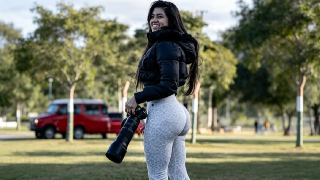 Fotógrafa deportiva Adriana Caballero sosteniendo su cámara en la cancha.
