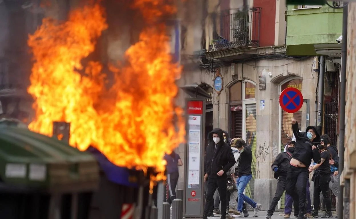 Efectivos de la Ertzaintza desplegados en la Avenida Lehendakari Agirre frente a barricadas en llamas.