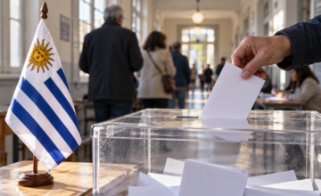 Urna de votación y banderas uruguayas durante una jornada electoral.
