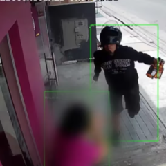 Captura de cámara de seguridad que muestra a un hombre con casco de motocicleta y un cuchillo en la mano.
