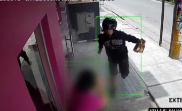 Captura de cámara de seguridad que muestra a un hombre con casco de motocicleta y un cuchillo en la mano.
