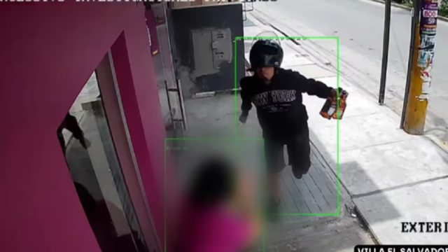 Captura de cámara de seguridad que muestra a un hombre con casco de motocicleta y un cuchillo en la mano.