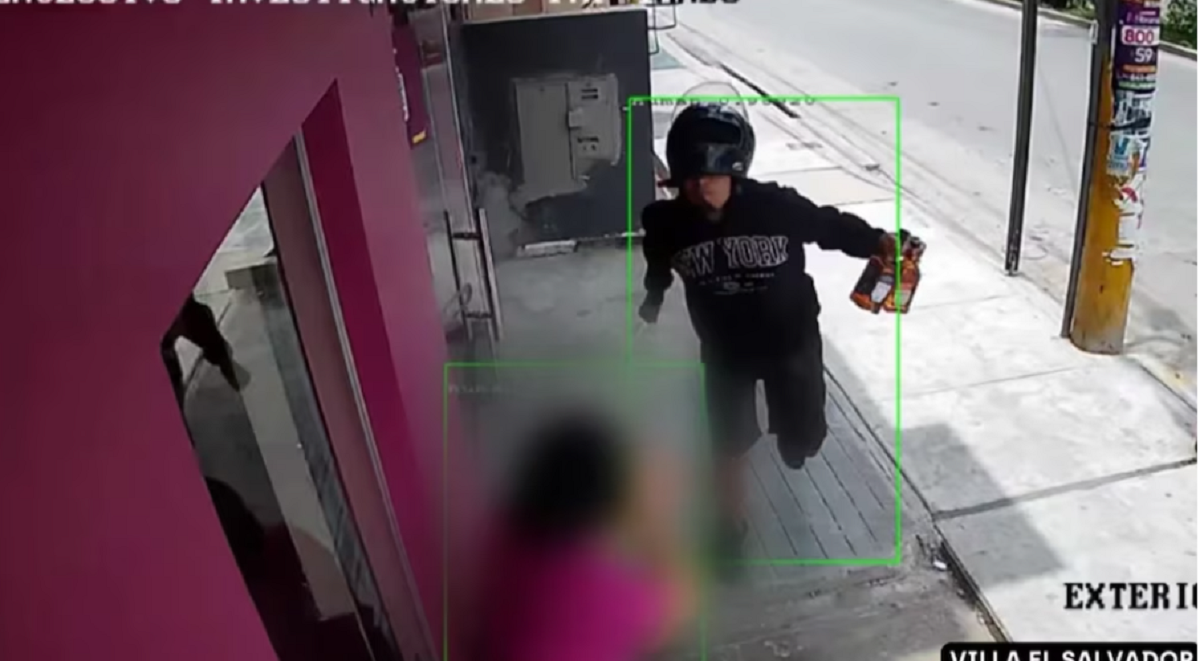 Captura de cámara de seguridad que muestra a un hombre con casco de motocicleta y un cuchillo en la mano.
