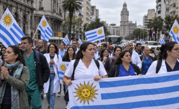 Funcionarios de la salud pública marchando con pancartas por la avenida.