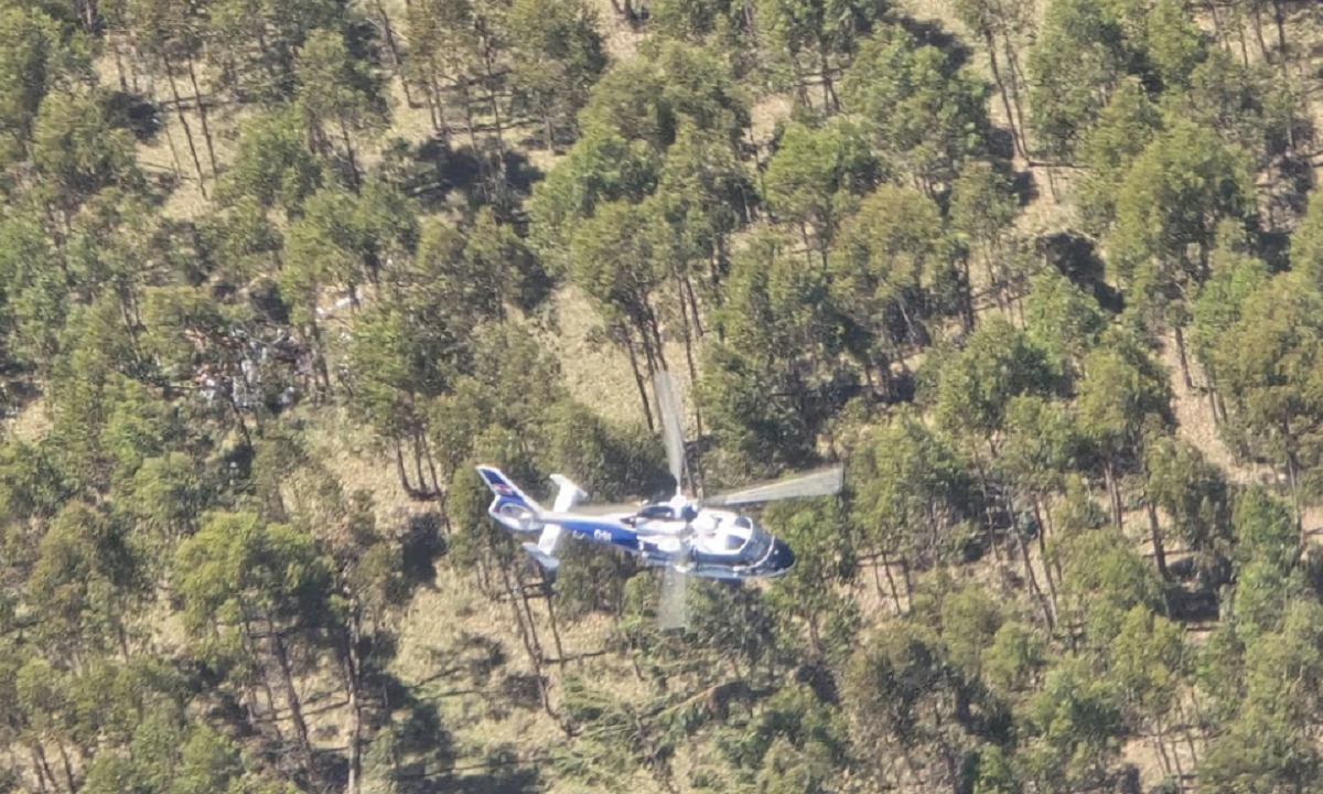 Avioneta de acrobacia sobrevolando un aeródromo rural.