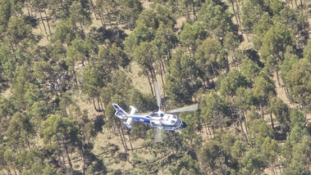 Avioneta de acrobacia sobrevolando un aeródromo rural.