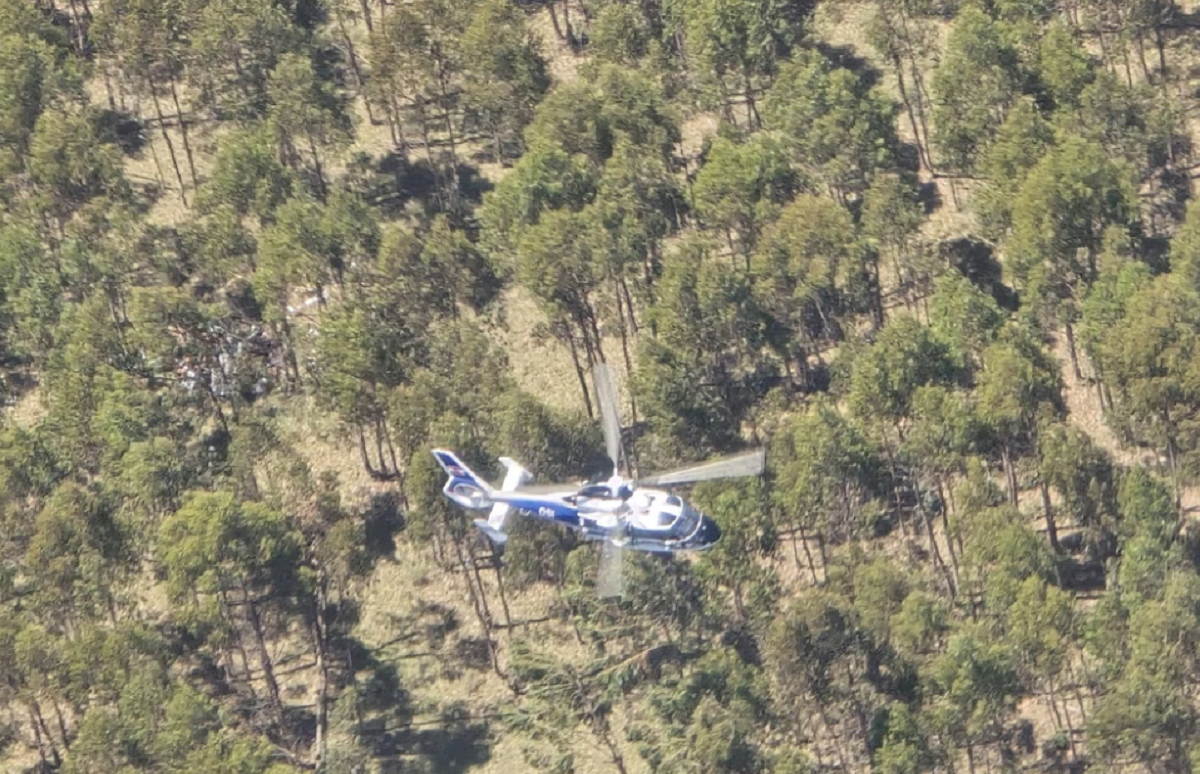 Avioneta de acrobacia sobrevolando un aeródromo rural.