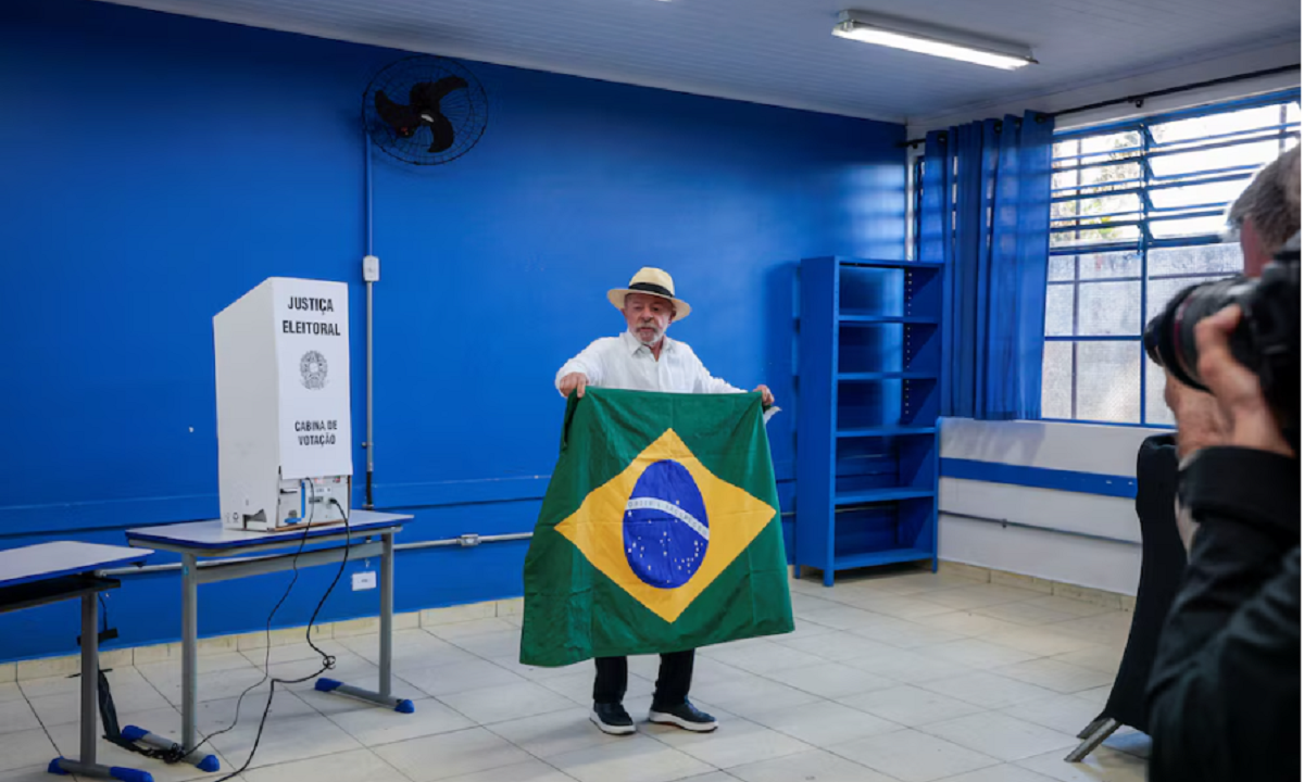 Lula da Silva exhibiendo la bandera de Brasil tras emitir su sufragio en San Pablo.