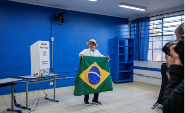 Lula da Silva exhibiendo la bandera de Brasil tras emitir su sufragio en San Pablo.