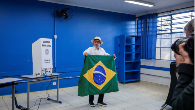 Lula da Silva exhibiendo la bandera de Brasil tras emitir su sufragio en San Pablo.