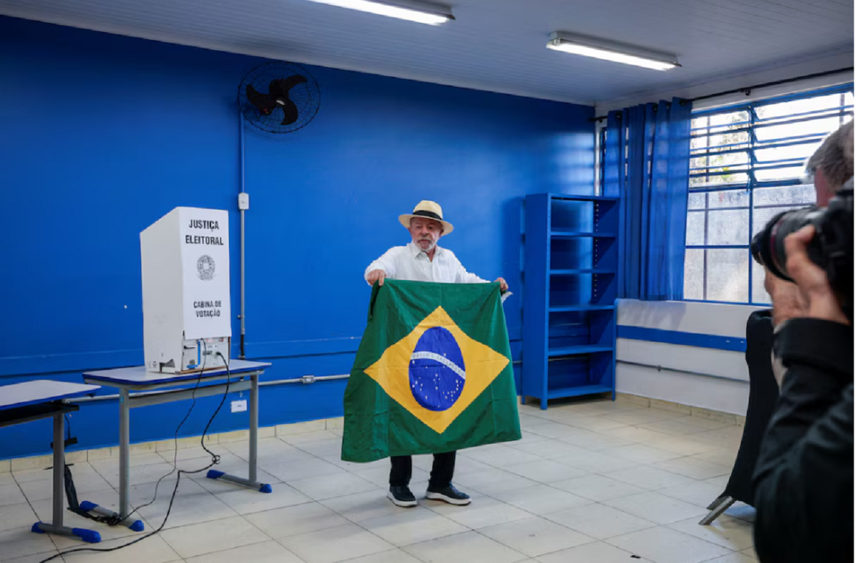Lula da Silva exhibiendo la bandera de Brasil tras emitir su sufragio en San Pablo.