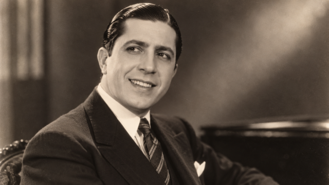Foto histórica de Carlos Gardel sonriendo con su característico sombrero.