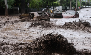 Vehículos varados en una avenida anegada por el granizo y la lluvia en Santiago de Chile.