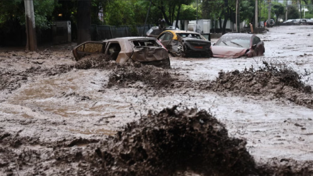 Vehículos varados en una avenida anegada por el granizo y la lluvia en Santiago de Chile.