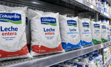 Sachets de leche fresca Conaprole alineados en la góndola de un supermercado