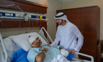 El príncipe heredero Hamdan bin Mohamed besando la cabeza vendada del piloto Smit Machchhar en la cama del hospital.