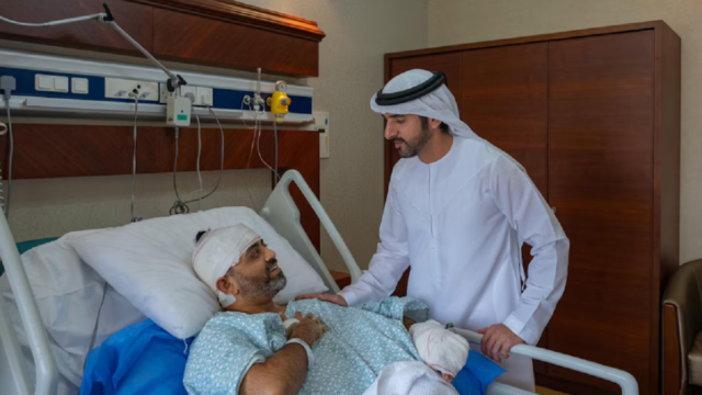 El príncipe heredero Hamdan bin Mohamed besando la cabeza vendada del piloto Smit Machchhar en la cama del hospital.