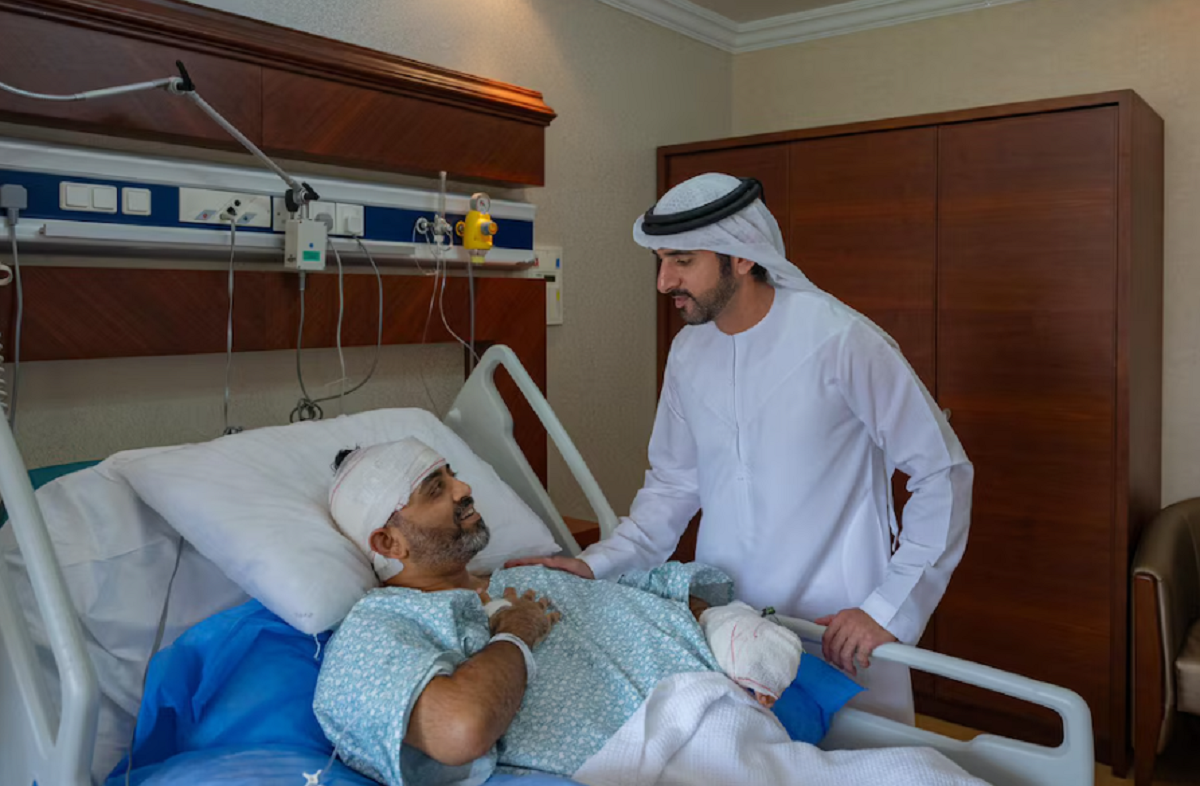 El príncipe heredero Hamdan bin Mohamed besando la cabeza vendada del piloto Smit Machchhar en la cama del hospital.