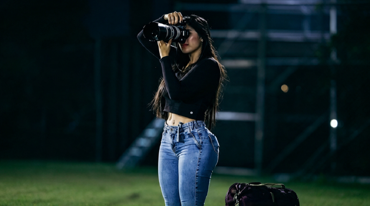 Reportera gráfica trabajando en el campo de juego durante un partido de fútbol.
