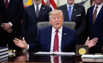Donald Trump hablando frente a micrófonos en un acto oficial.