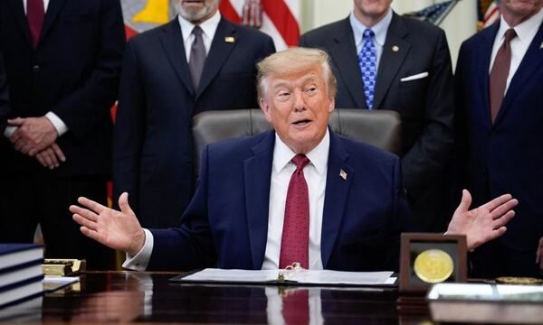 Donald Trump hablando frente a micrófonos en un acto oficial.