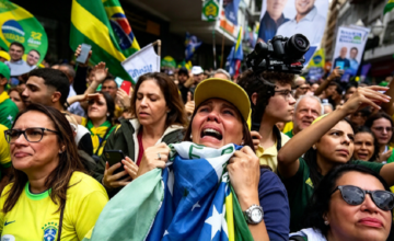 Militantes bolsonaristas agitando banderas de Brasil frente a la residencia de Barra da Tijuca en Río de Janeiro.