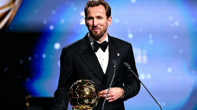 Harry Kane sonriente sosteniendo el trofeo dorado que lo distingue como el mejor jugador del mundo.