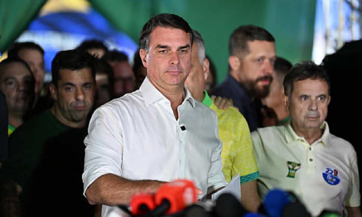 El senador brasileño Flávio Bolsonaro hablando ante micrófonos en una rueda de prensa.