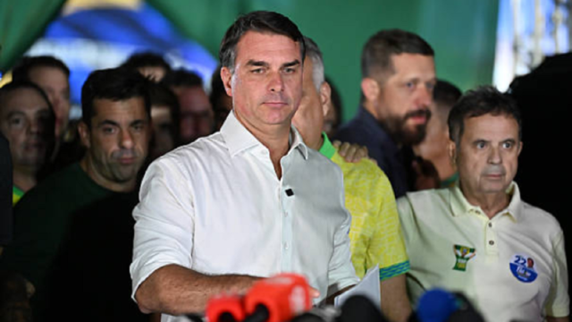 El senador brasileño Flávio Bolsonaro hablando ante micrófonos en una rueda de prensa.