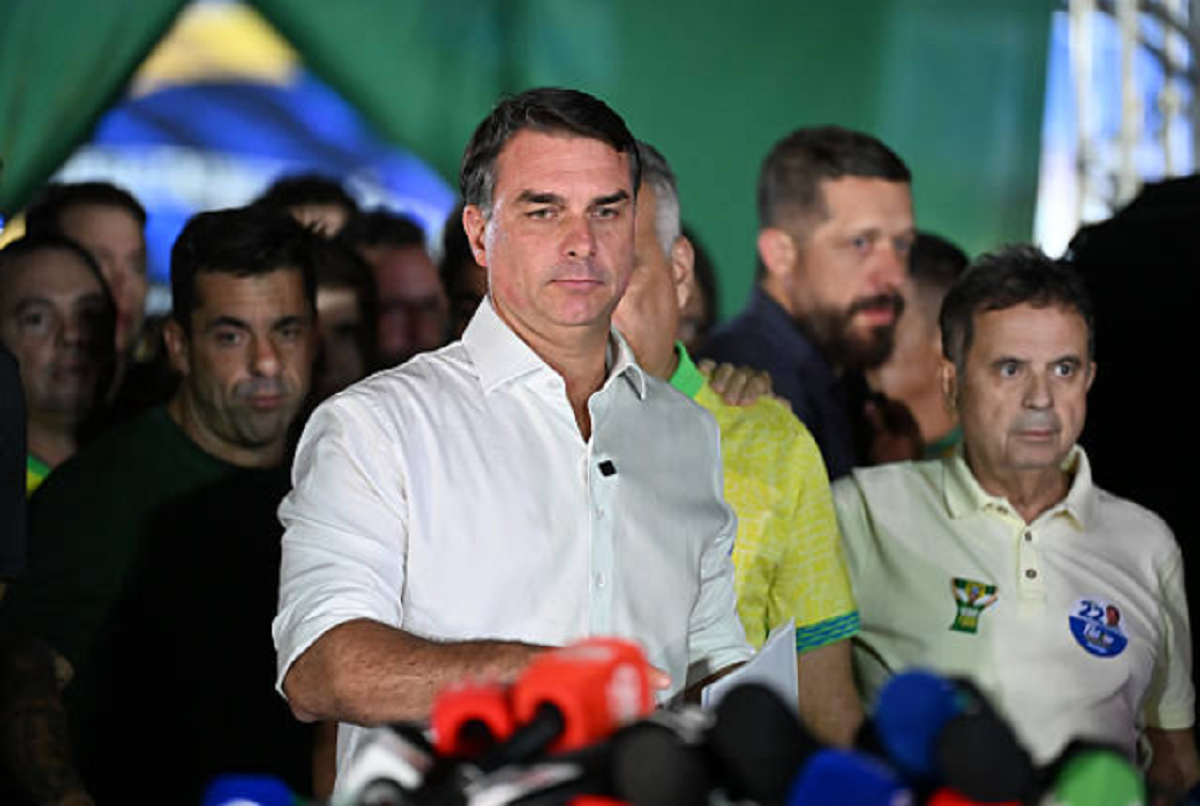 El senador brasileño Flávio Bolsonaro hablando ante micrófonos en una rueda de prensa.